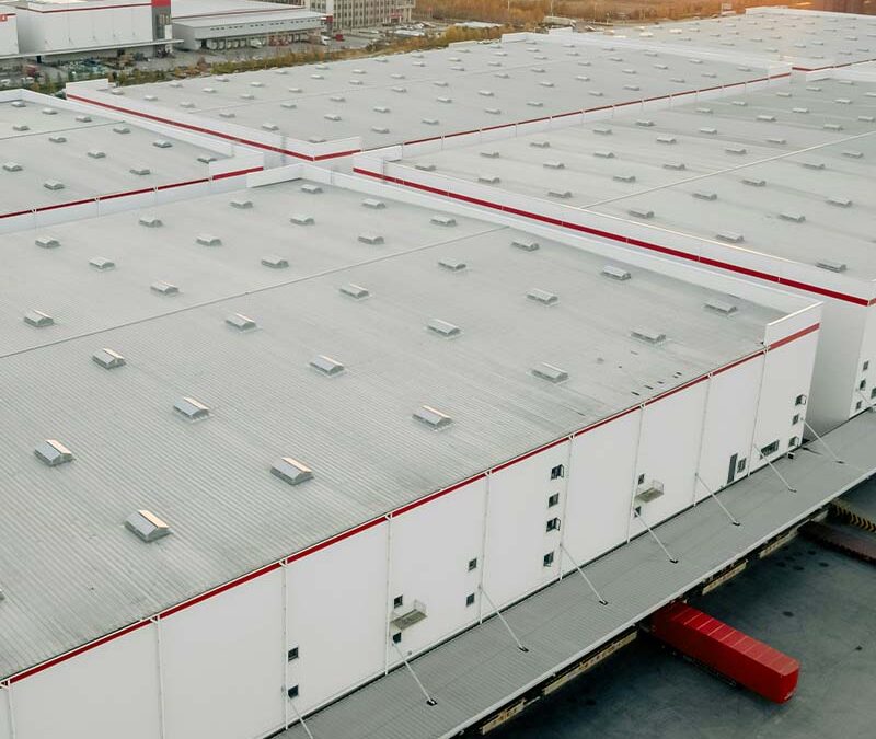 Vue aérienne d’un entrepôt logistique moderne avec quai de chargement.